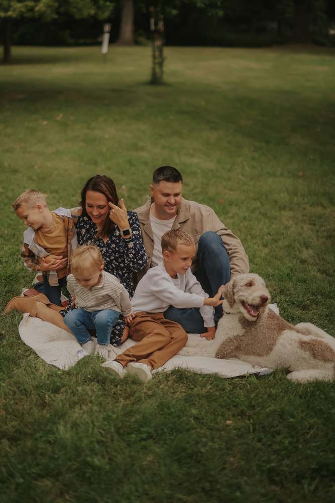 The family sitting together on the grass