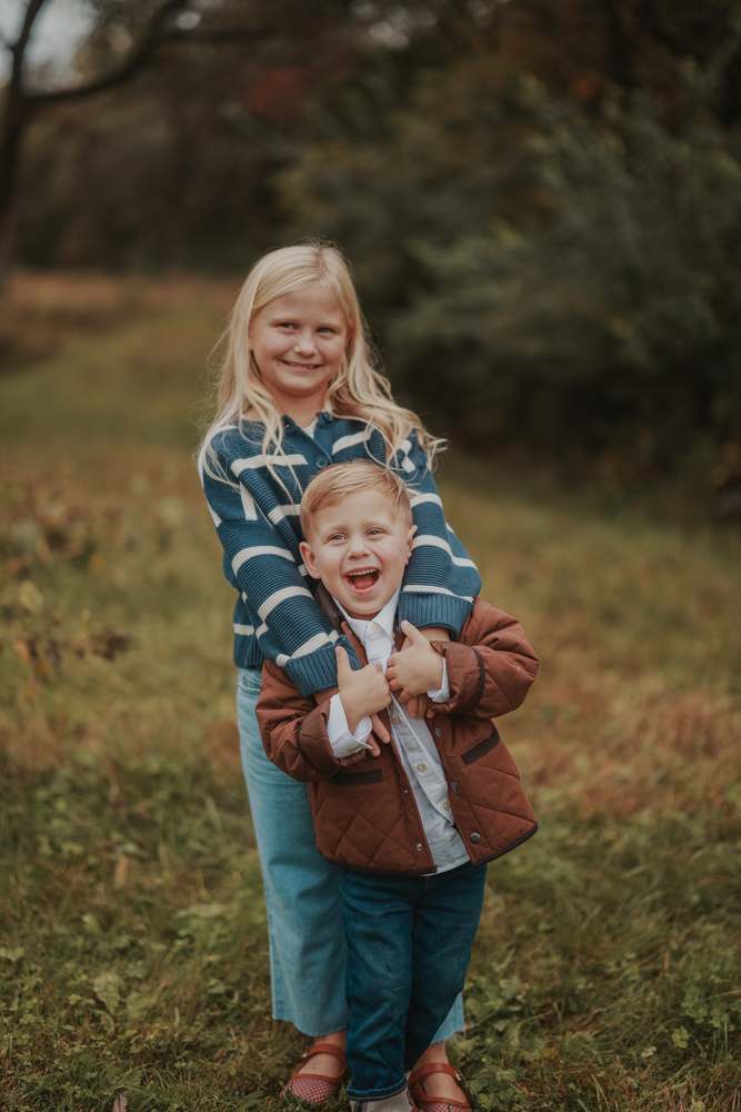 A big sister holding on to her little brother