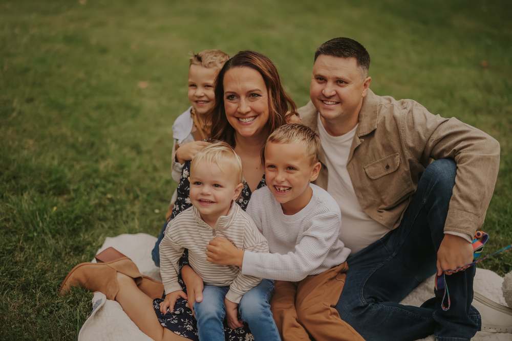 A family of five laughing together on the blanket