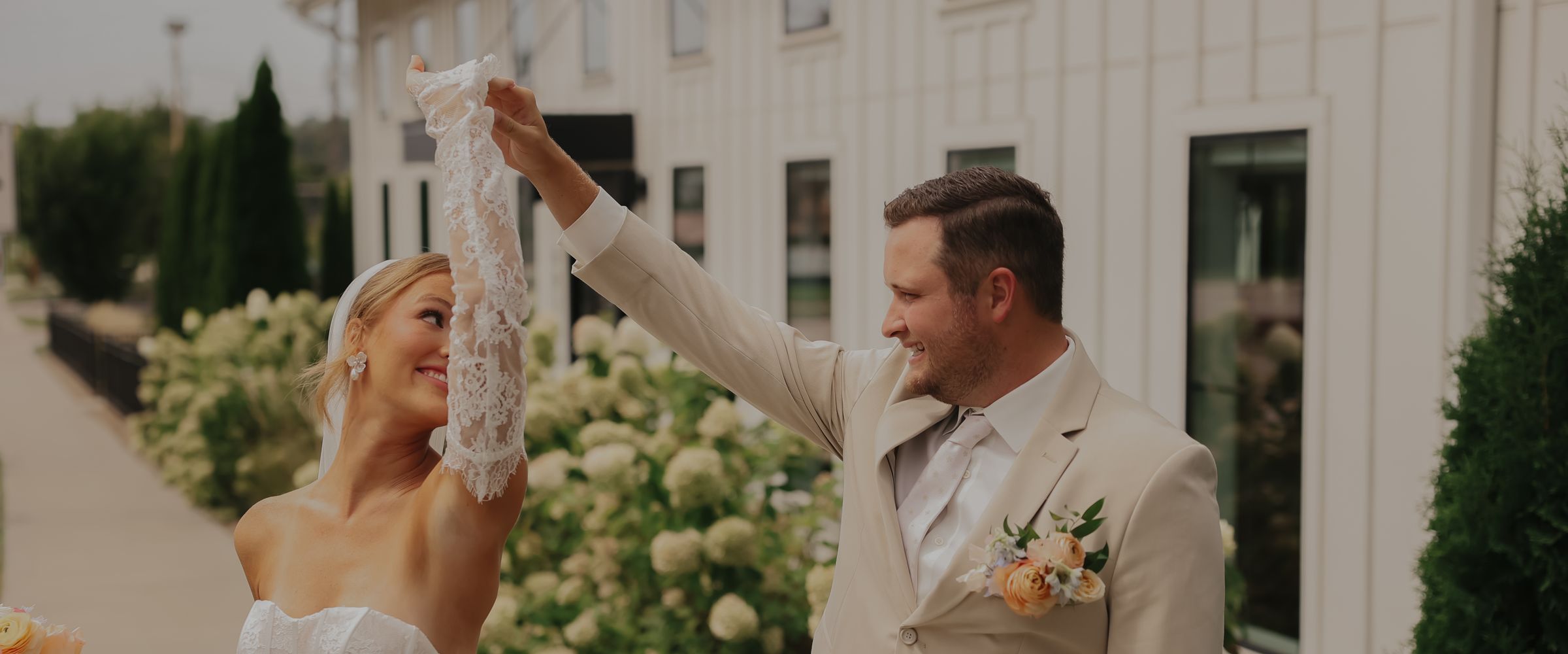 A groom spinning his bride on the walk outside the venue