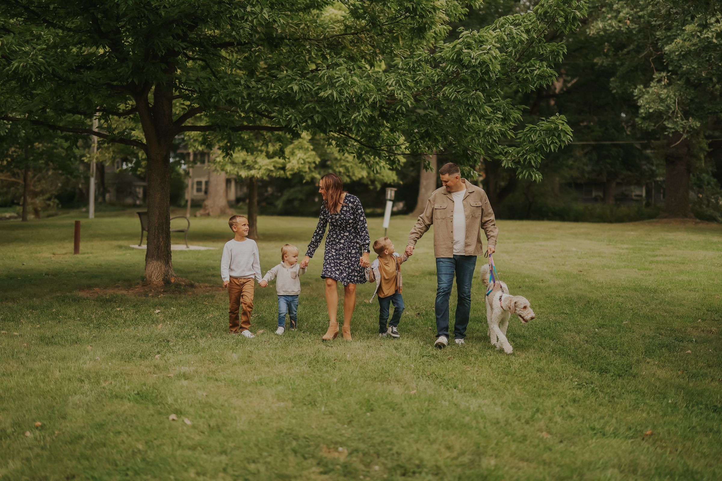 A family walking the park together with their dog
