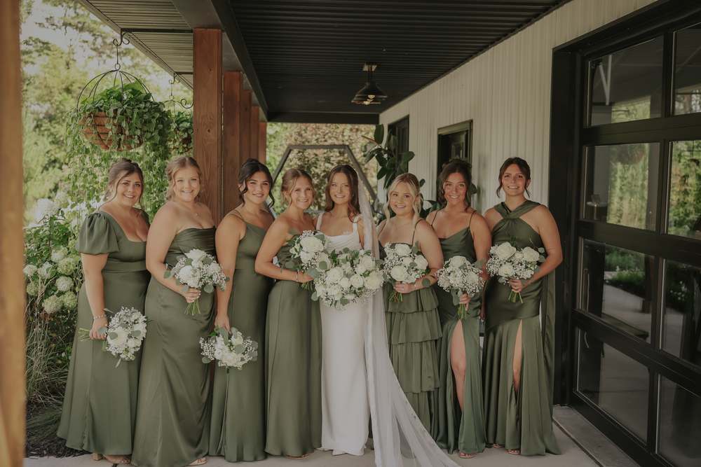 The bridesmaids in olive along the porch