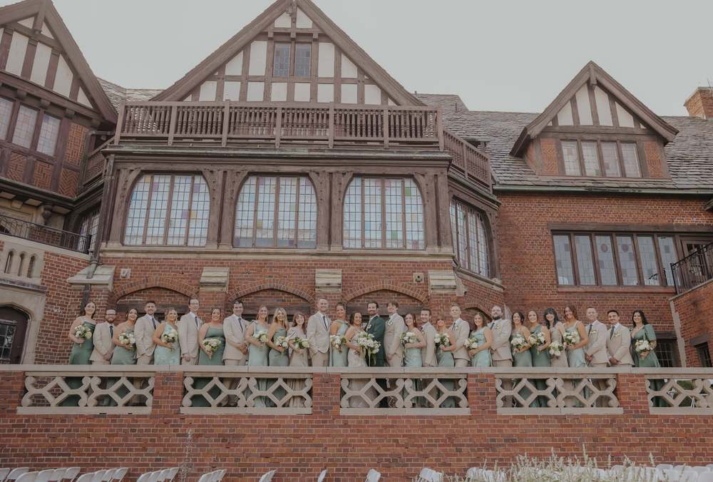 The whole wedding party across the front of the house