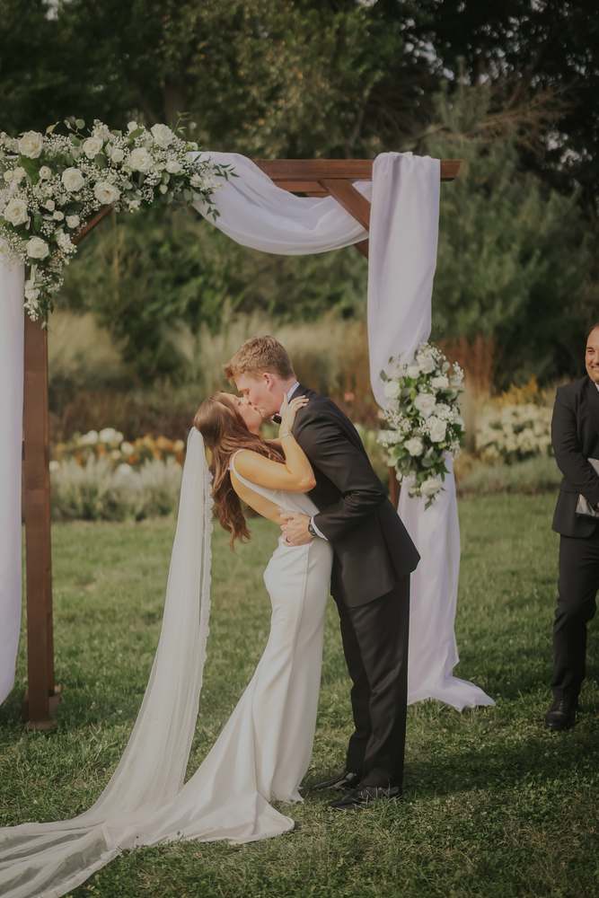 A kiss beneath the ceremony arch