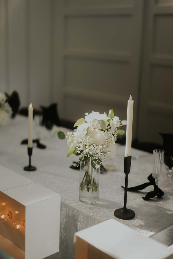 Black tapers and white blooms along the head table