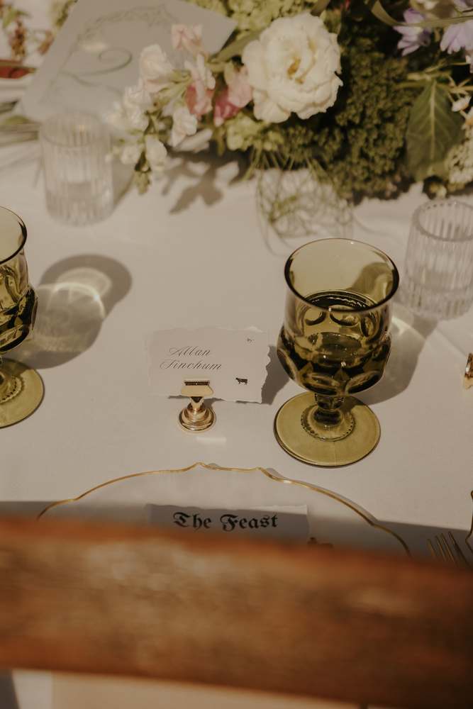 Green goblets and gold flatware at each seat